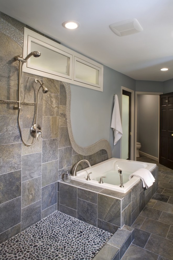 Cette image montre une douche en alcôve principale traditionnelle en bois foncé avec un placard avec porte à panneau encastré, une baignoire posée, un mur bleu, un sol en ardoise et un plan de toilette en calcaire.