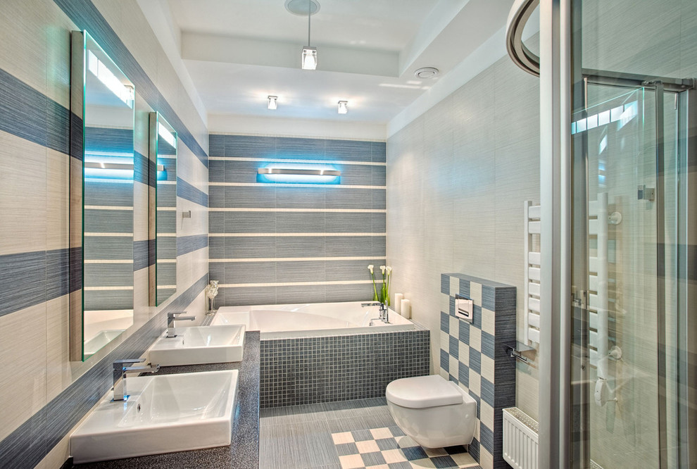 Inspiration för ett funkis badrum, med ett fristående handfat, ett platsbyggt badkar, en hörndusch, en vägghängd toalettstol och blå kakel