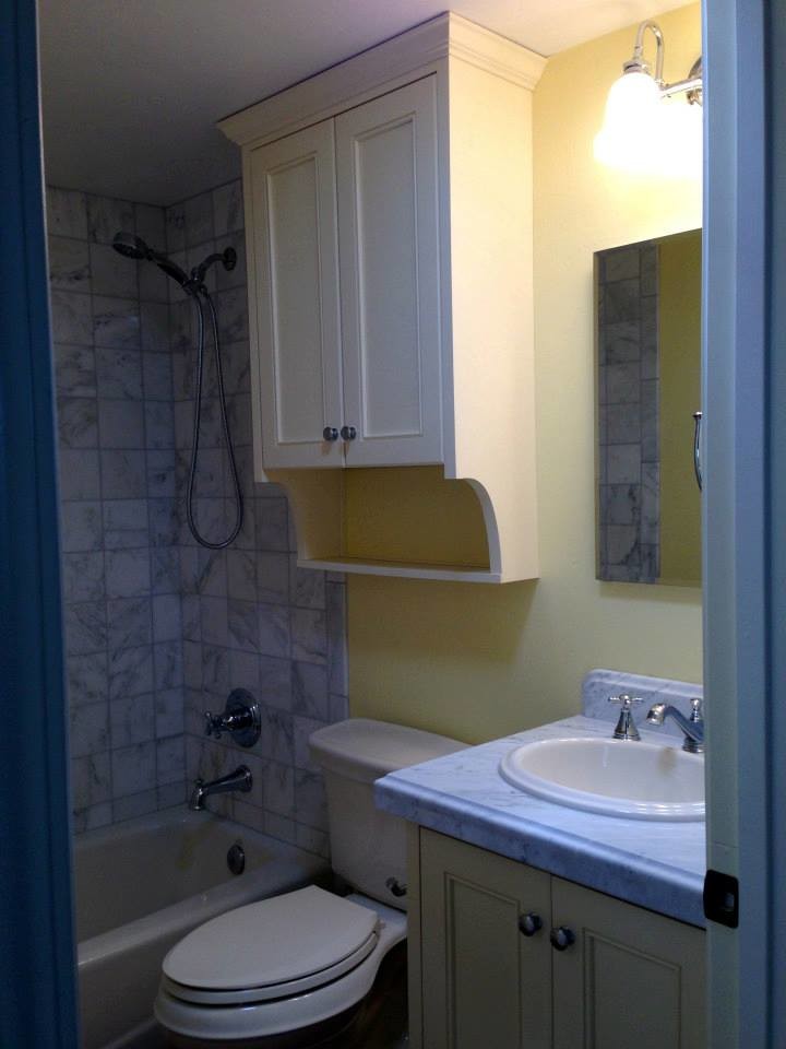 Esempio di una piccola stanza da bagno con doccia eclettica con piastrelle grigie, pareti gialle, ante a filo, ante gialle, vasca ad alcova, doccia alcova, WC a due pezzi, piastrelle in pietra, lavabo da incasso e top in marmo