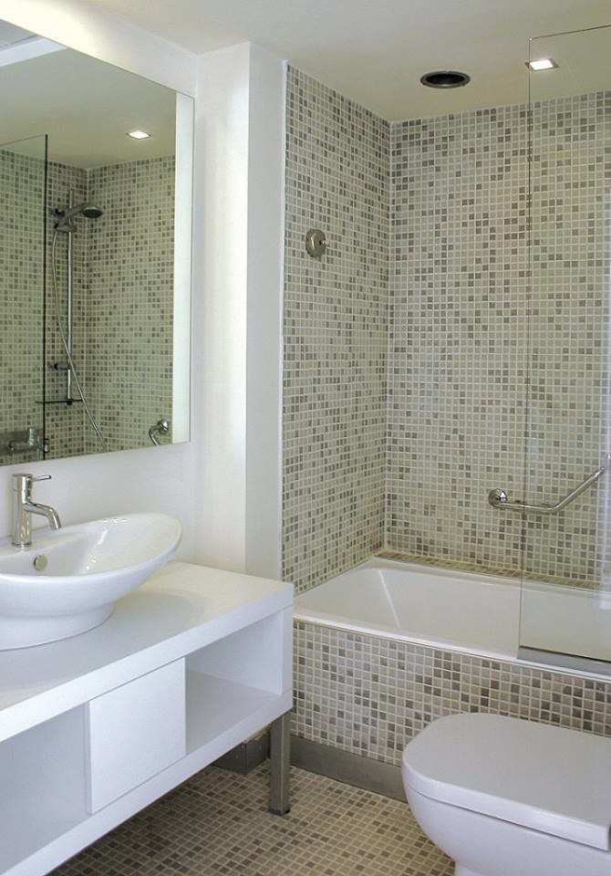 Photo of a medium sized modern ensuite bathroom in Toronto with a vessel sink, white cabinets, a shower/bath combination, a two-piece toilet, multi-coloured tiles, glass tiles, white walls and mosaic tile flooring.