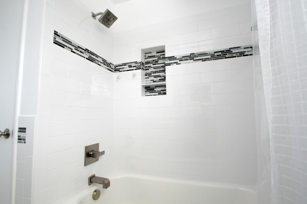 Idée de décoration pour une petite salle d'eau design avec un placard à porte plane, des portes de placard grises, une baignoire en alcôve, un combiné douche/baignoire, WC à poser, un carrelage noir et blanc, un carrelage gris, un carrelage métro, un mur blanc, un sol en marbre, un lavabo intégré et un plan de toilette en surface solide.