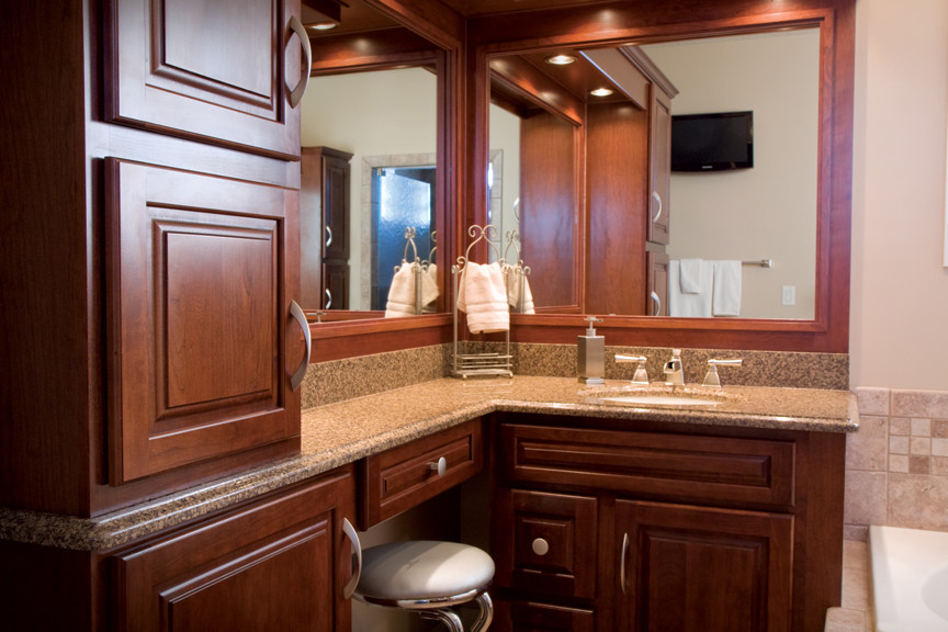 Photo of a medium sized classic ensuite bathroom in Chicago with raised-panel cabinets, medium wood cabinets, a built-in bath, beige tiles, ceramic tiles, beige walls, a submerged sink and granite worktops.