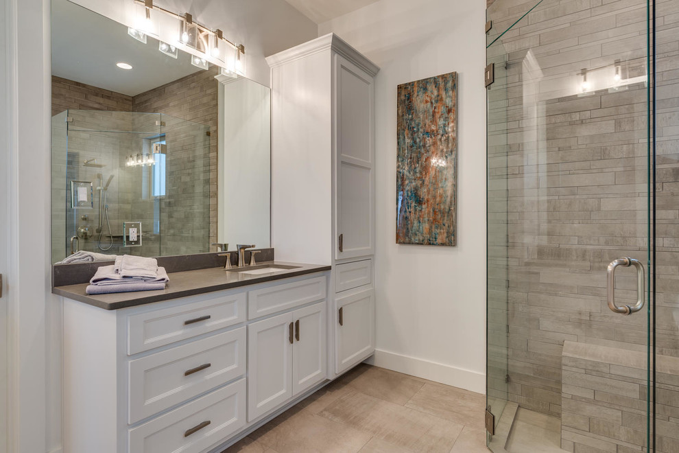 Bathroom - large contemporary master beige tile and stone tile porcelain tile and beige floor bathroom idea in Austin with recessed-panel cabinets, white cabinets, white walls, an undermount sink and a hinged shower door