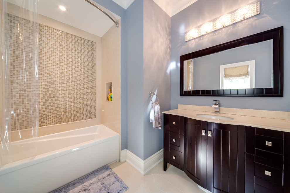 Cette image montre une salle d'eau design de taille moyenne avec un placard avec porte à panneau encastré, des portes de placard marrons, une baignoire en alcôve, un combiné douche/baignoire, un carrelage beige, un carrelage marron, mosaïque, un mur bleu, un sol en carrelage de porcelaine, un lavabo encastré, un plan de toilette en quartz, un sol beige et une cabine de douche avec un rideau.