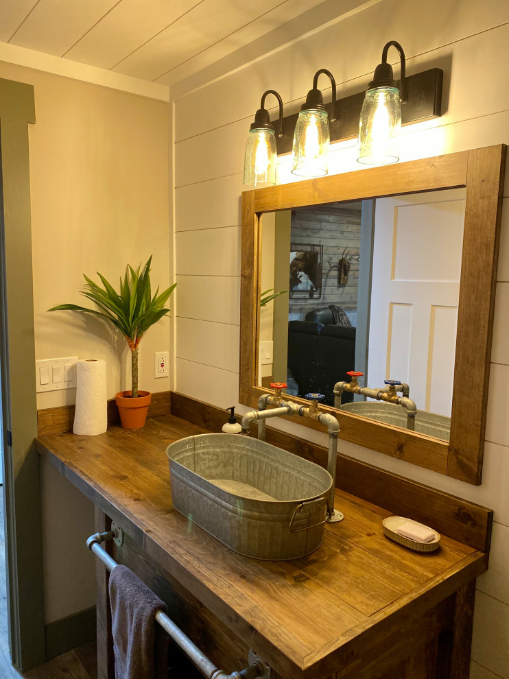 Foto på ett mellanstort rustikt brun badrum med dusch, med möbel-liknande, bruna skåp, en öppen dusch, en toalettstol med hel cisternkåpa, vita väggar, vinylgolv, ett fristående handfat, träbänkskiva och grått golv