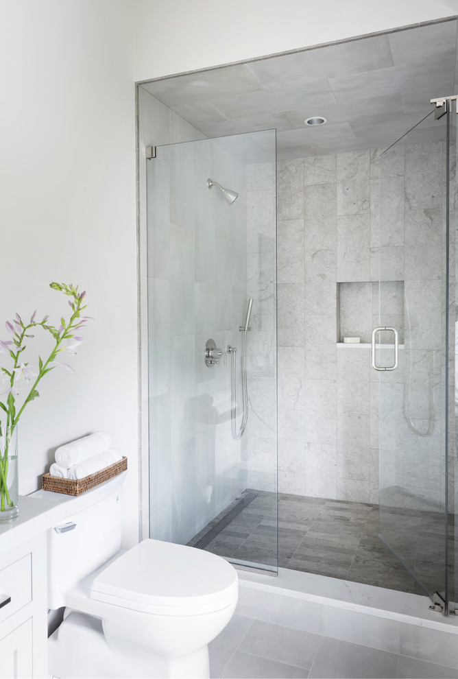 Small modern shower room bathroom in New York with white cabinets, an alcove shower, a two-piece toilet, beige tiles, porcelain tiles, white walls, porcelain flooring, a submerged sink, engineered stone worktops, grey floors and a hinged door.