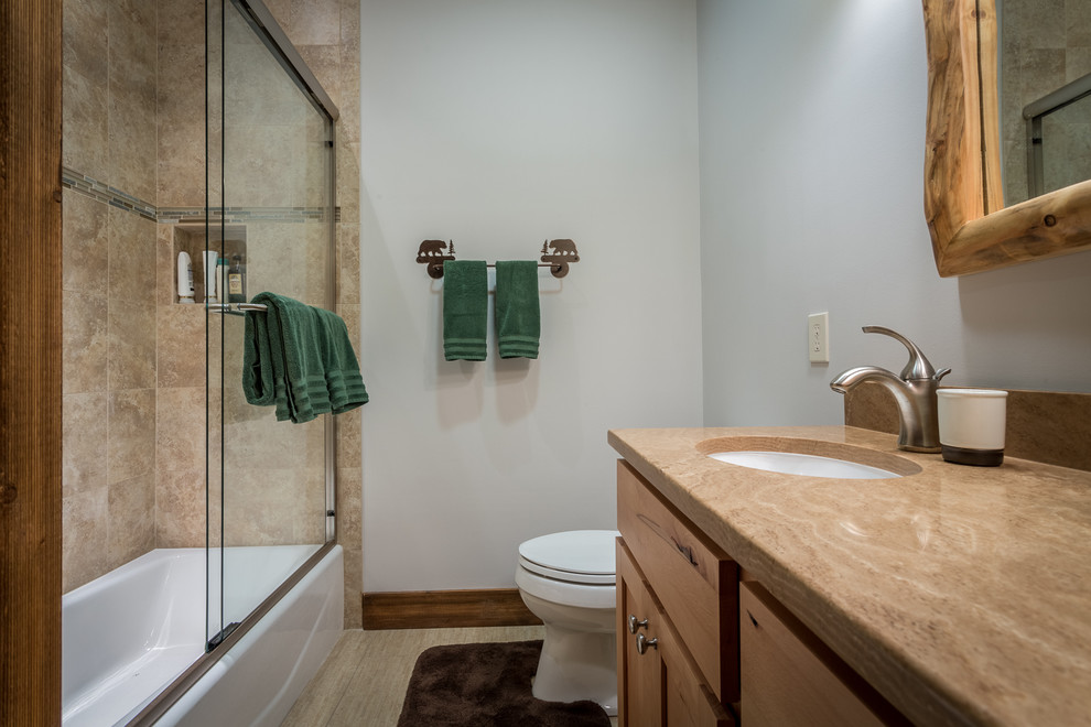 Bathroom - mid-sized rustic beige tile and ceramic tile ceramic tile and beige floor bathroom idea in Charlotte with an undermount sink, shaker cabinets, light wood cabinets, granite countertops, a two-piece toilet and gray walls