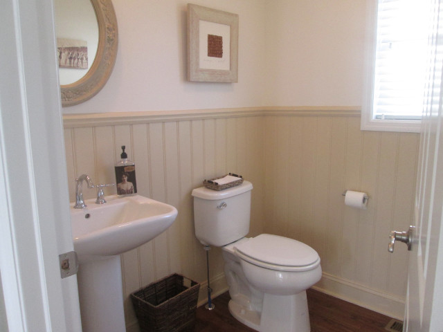 Foto de cuarto de baño costero pequeño con lavabo con pedestal, paredes beige y suelo de madera oscura