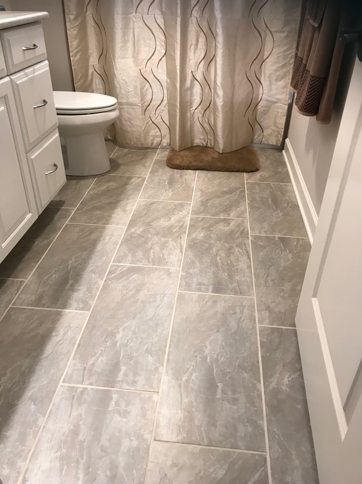 This is an example of a medium sized mediterranean family bathroom in Baltimore with raised-panel cabinets, white cabinets, an alcove bath, a two-piece toilet, brown tiles, ceramic tiles, grey walls, ceramic flooring, a built-in sink, granite worktops, beige floors and a shower curtain.