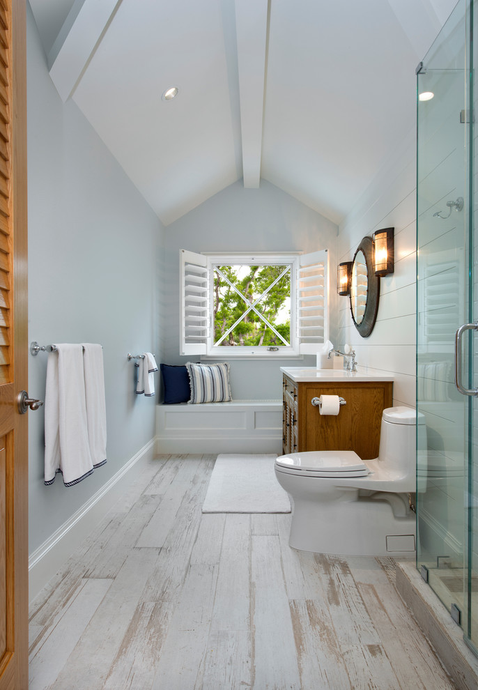 Стильный дизайн: большая ванная комната в морском стиле с фасадами цвета дерева среднего тона, душем в нише, унитазом-моноблоком, серыми стенами, деревянным полом, душевой кабиной, врезной раковиной, белым полом, душем с распашными дверями, белой столешницей и фасадами с филенкой типа жалюзи - последний тренд