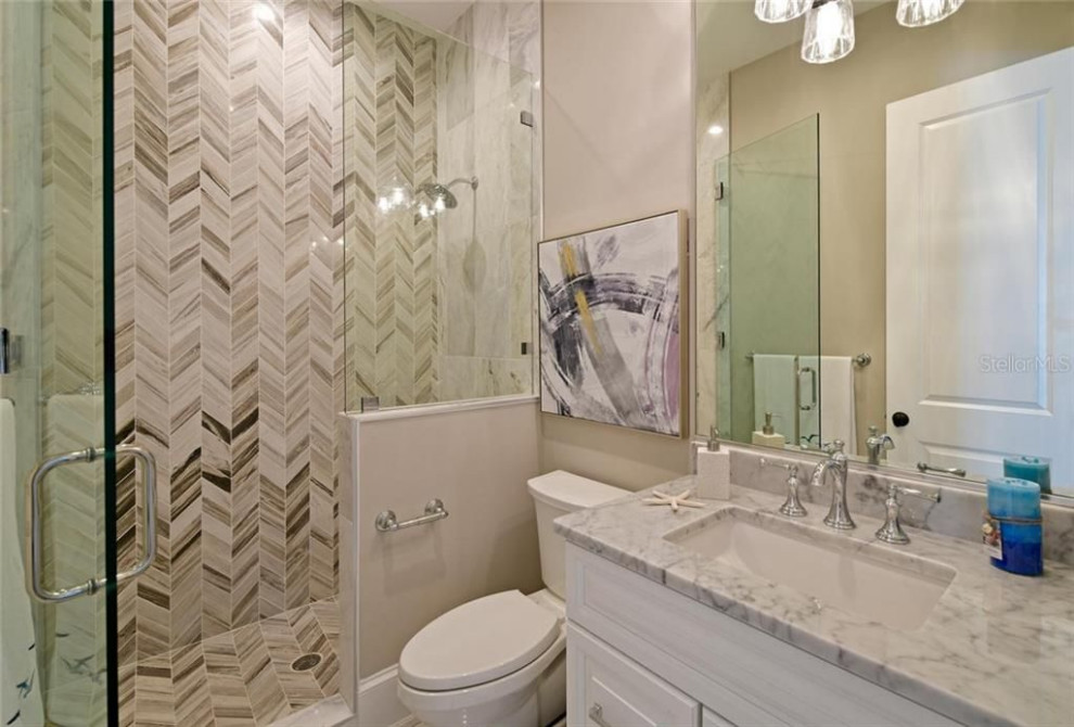 Exemple d'une salle de bain bord de mer avec un placard en trompe-l'oeil, des portes de placard blanches, un plan de toilette en marbre, un sol multicolore, un plan de toilette multicolore, meuble double vasque et meuble-lavabo encastré.