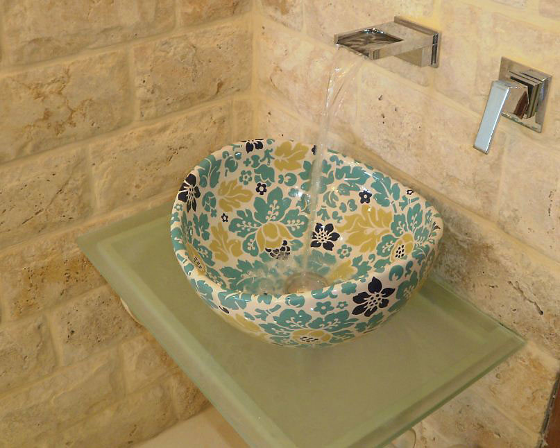 高級な地中海スタイルのおしゃれな浴室 (ガラスの洗面台、ベッセル式洗面器、石タイル、ベージュの壁) の写真
