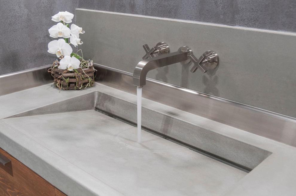 Immagine di una stanza da bagno padronale minimalista di medie dimensioni con ante lisce, ante in legno scuro, pareti grigie, lavabo integrato e top in cemento