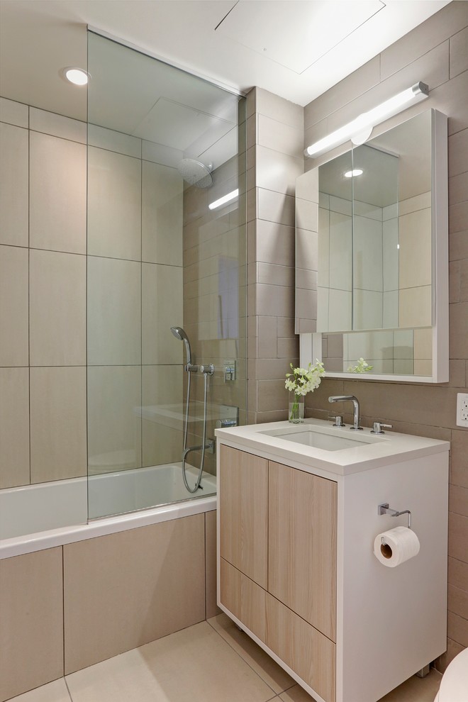 Foto på ett mellanstort funkis en-suite badrum, med ett undermonterad handfat, släta luckor, ett badkar i en alkov, en dusch/badkar-kombination, grå skåp, en toalettstol med hel cisternkåpa, flerfärgad kakel, porslinskakel, grå väggar och bänkskiva i kvarts