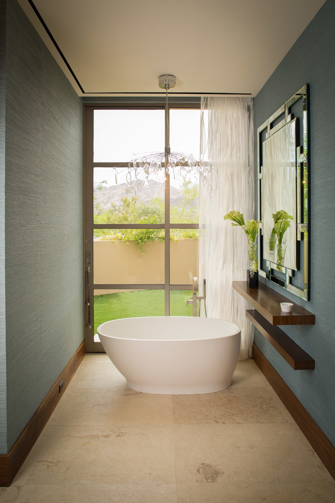 Ejemplo de cuarto de baño principal contemporáneo con armarios abiertos, puertas de armario de madera en tonos medios, bañera exenta, paredes azules y ventanas
