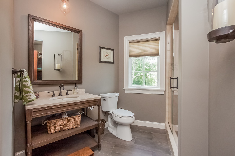 Immagine di una stanza da bagno industriale con lavabo sottopiano, doccia alcova, WC monopezzo e pareti grigie