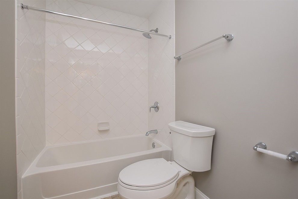 Свежая идея для дизайна: ванная комната среднего размера в стиле неоклассика (современная классика) с ванной в нише, душем над ванной, раздельным унитазом, белой плиткой, керамогранитной плиткой, серыми стенами, душевой кабиной, шторкой для ванной и белой столешницей - отличное фото интерьера