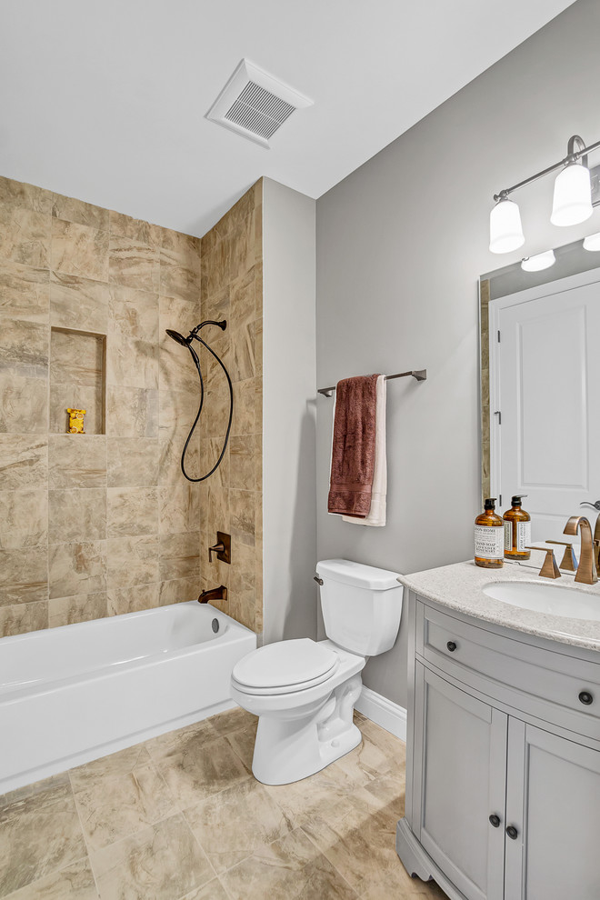 На фото: ванная комната в стиле неоклассика (современная классика) с душем над ванной, керамической плиткой, полом из керамической плитки, столешницей из гранита, шторкой для ванной, фасадами в стиле шейкер, серыми фасадами, ванной в нише, раздельным унитазом, коричневой плиткой, серыми стенами, врезной раковиной и коричневым полом