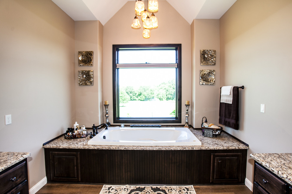 Aménagement d'une grande salle de bain craftsman avec une douche ouverte, un sol en bois brun, un plan de toilette en granite, un sol marron et une cabine de douche à porte coulissante.