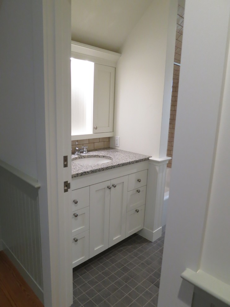 Cette image montre une petite salle de bain traditionnelle avec un lavabo encastré, un placard à porte shaker, des portes de placard blanches, un plan de toilette en granite, un carrelage beige, un carrelage métro, un mur blanc et un sol en carrelage de céramique.