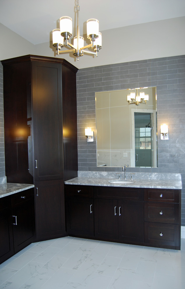 Immagine di una grande stanza da bagno padronale chic con ante in stile shaker, ante nere, vasca da incasso, piastrelle grigie, piastrelle diamantate, pareti beige, lavabo sottopiano e top in granito