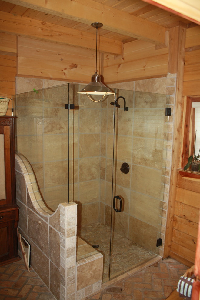 На фото: главная ванная комната среднего размера в стиле рустика с столешницей из гранита, угловым душем, коричневой плиткой, каменной плиткой, коричневыми стенами и кирпичным полом с
