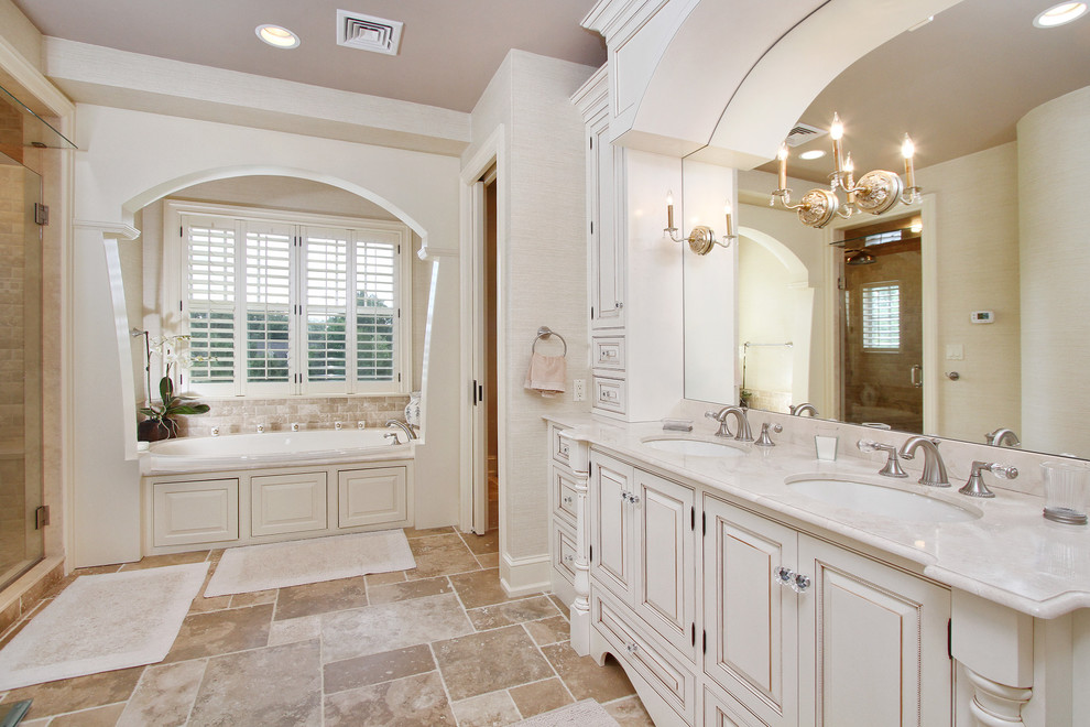 На фото: ванная комната в классическом стиле с белыми фасадами, ванной в нише, врезной раковиной, душем в нише, унитазом-моноблоком, разноцветной плиткой, бежевыми стенами и фасадами с выступающей филенкой