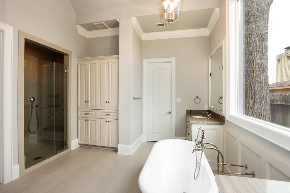 Klassisk inredning av ett en-suite badrum, med vita skåp, ett fristående badkar och en dusch i en alkov
