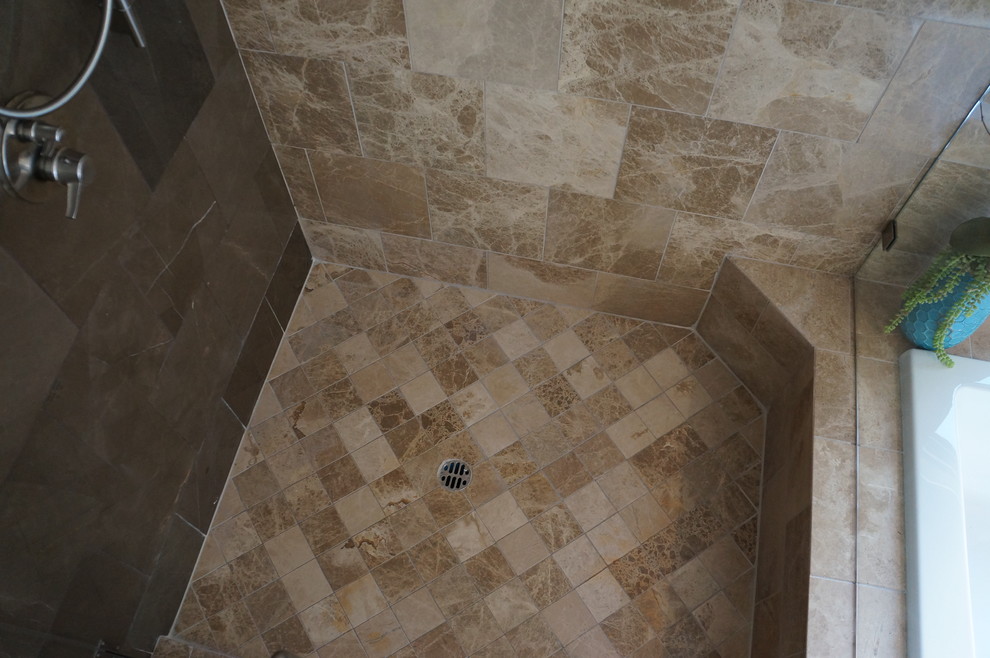 Idée de décoration pour une grande salle de bain principale design avec un lavabo posé, un plan de toilette en marbre, une baignoire posée, un carrelage marron, un carrelage de pierre et un sol en travertin.