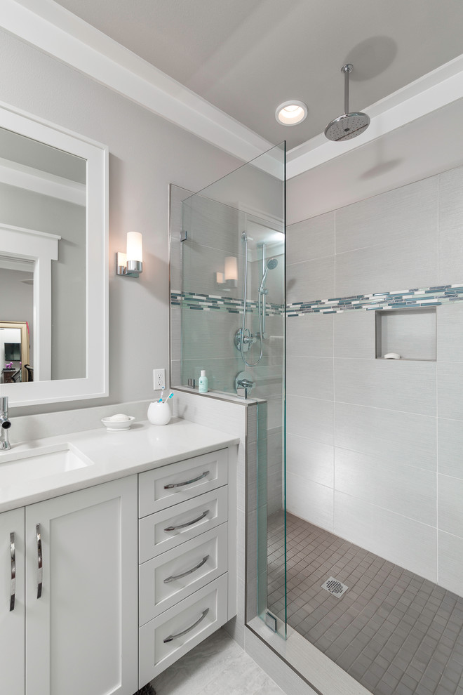 Inredning av ett maritimt mellanstort badrum med dusch, med ett undermonterad handfat, luckor med infälld panel, vita skåp, ett platsbyggt badkar, en dusch i en alkov, grå kakel, grå väggar och marmorgolv