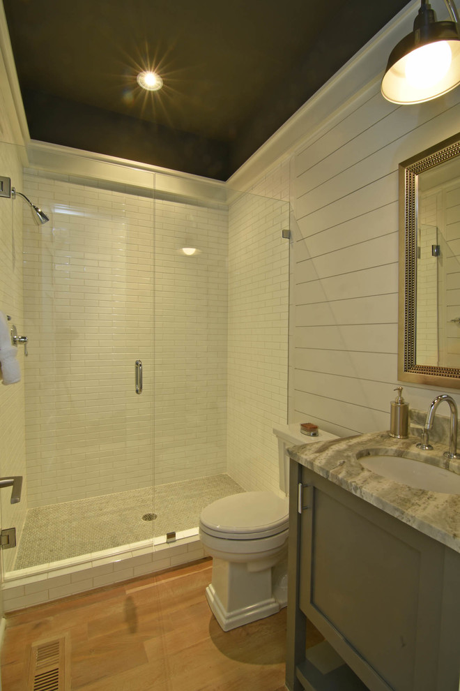 Идея дизайна: ванная комната в стиле неоклассика (современная классика) с плоскими фасадами, серыми фасадами, столешницей из гранита, белой плиткой, плиткой кабанчик и паркетным полом среднего тона