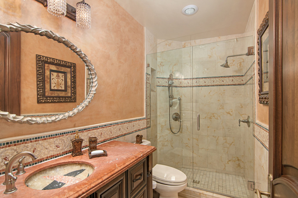 Bathroom - mid-sized traditional beige tile and stone tile marble floor bathroom idea in San Diego with raised-panel cabinets, dark wood cabinets, multicolored walls and marble countertops