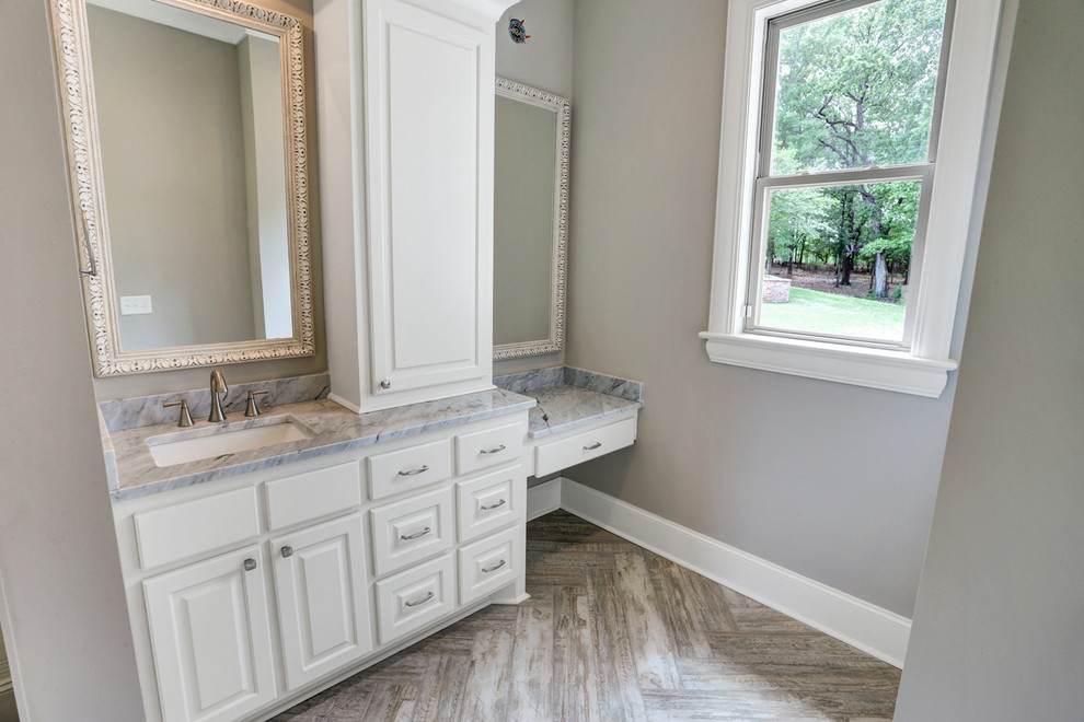 This is an example of a farmhouse bathroom in Jackson with raised-panel cabinets, white cabinets, a freestanding bath, grey walls, marble flooring, a submerged sink, marble worktops, grey floors and grey worktops.