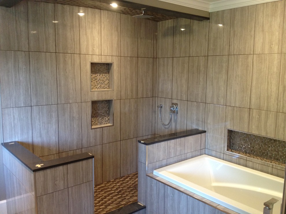 Foto de cuarto de baño principal moderno grande con bañera encastrada, baldosas y/o azulejos grises, baldosas y/o azulejos de porcelana y suelo de baldosas de porcelana
