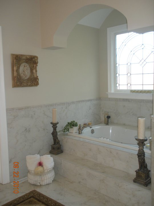 На фото: огромная главная ванная комната в средиземноморском стиле с фасадами с выступающей филенкой, бежевыми фасадами, накладной ванной, открытым душем, белой плиткой, мраморной плиткой, бежевыми стенами, мраморным полом, врезной раковиной, столешницей из гранита, белым полом, открытым душем, белой столешницей, сиденьем для душа, тумбой под две раковины, встроенной тумбой и кессонным потолком с