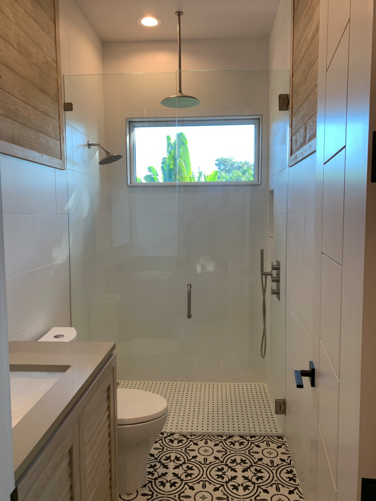 Doorless shower - mid-sized mid-century modern white tile and porcelain tile porcelain tile and multicolored floor doorless shower idea in Tampa with louvered cabinets, brown cabinets, a one-piece toilet, white walls, an undermount sink, quartz countertops, a hinged shower door and beige countertops