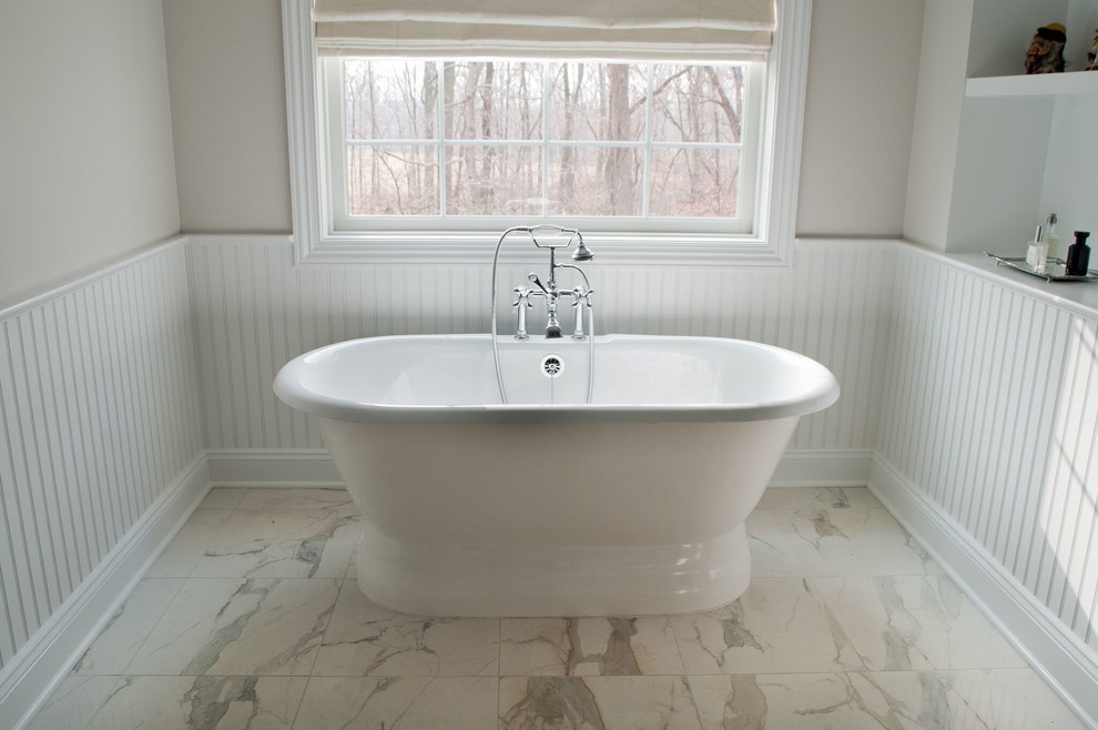 ニューヨークにあるトラディショナルスタイルのおしゃれな浴室 (置き型浴槽、磁器タイルの床、白い床、羽目板の壁) の写真