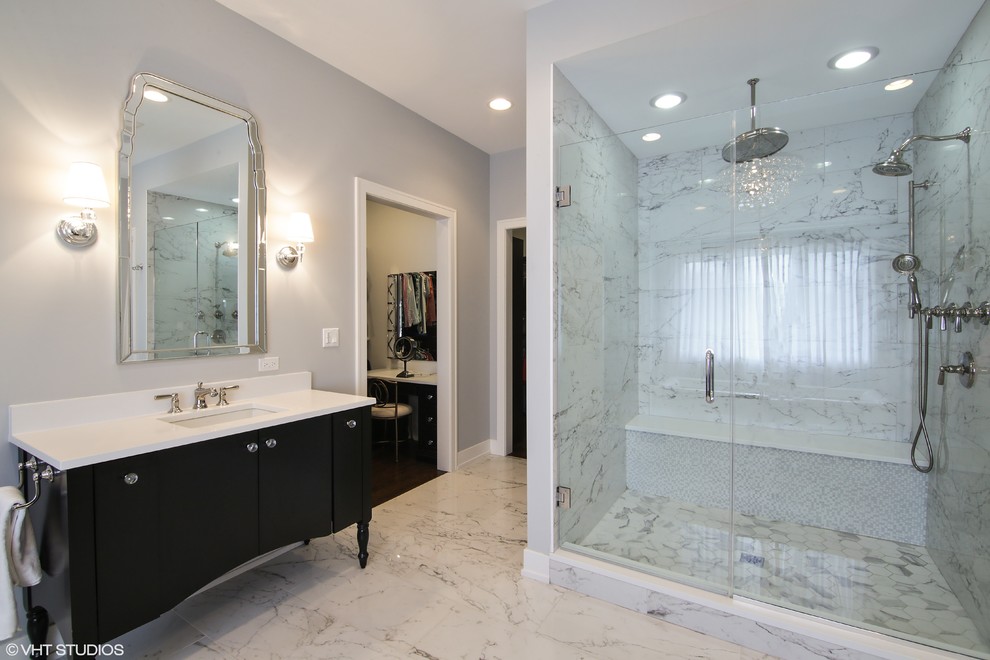 Klassisk inredning av ett stort en-suite badrum, med svarta skåp, ett fristående badkar, grå väggar, marmorgolv, ett undermonterad handfat och vitt golv