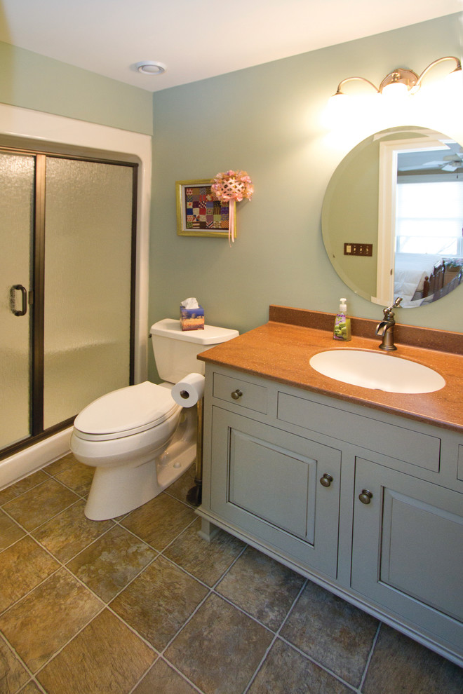 Ejemplo de cuarto de baño clásico de tamaño medio con lavabo bajoencimera, armarios tipo mueble, puertas de armario grises, encimera de granito, paredes verdes, suelo de linóleo, ducha empotrada, sanitario de dos piezas y aseo y ducha
