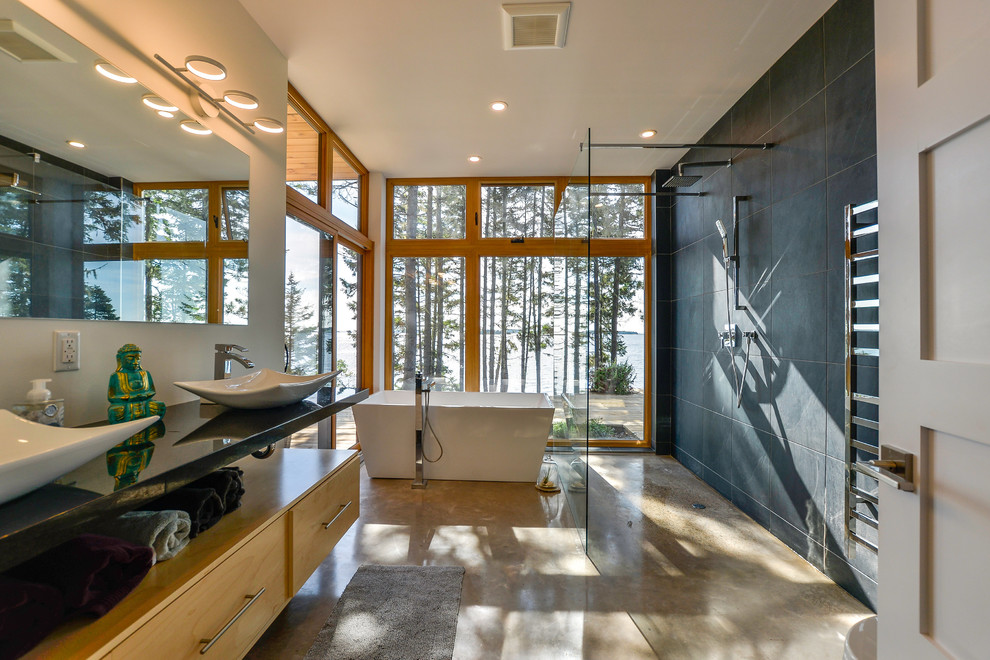 Modern inredning av ett stort en-suite badrum, med släta luckor, skåp i ljust trä, ett fristående badkar, en öppen dusch, svart kakel, porslinskakel, vita väggar, ett fristående handfat, beiget golv, med dusch som är öppen och betonggolv