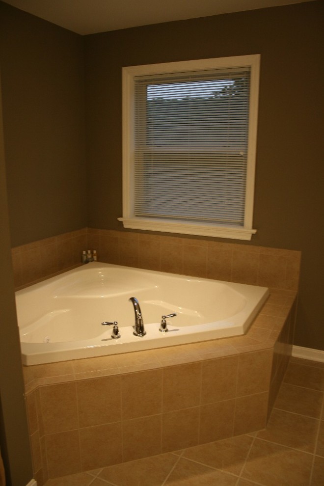 Foto de cuarto de baño principal clásico renovado de tamaño medio con bañera esquinera y suelo beige