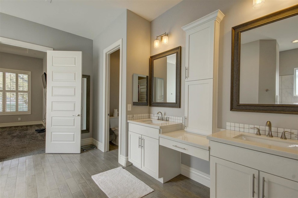 Inspiration pour une salle de bain principale craftsman de taille moyenne avec un placard à porte shaker, des portes de placard blanches, WC à poser, un carrelage blanc, mosaïque, un mur gris, un sol en contreplaqué, un lavabo encastré et un plan de toilette en carrelage.