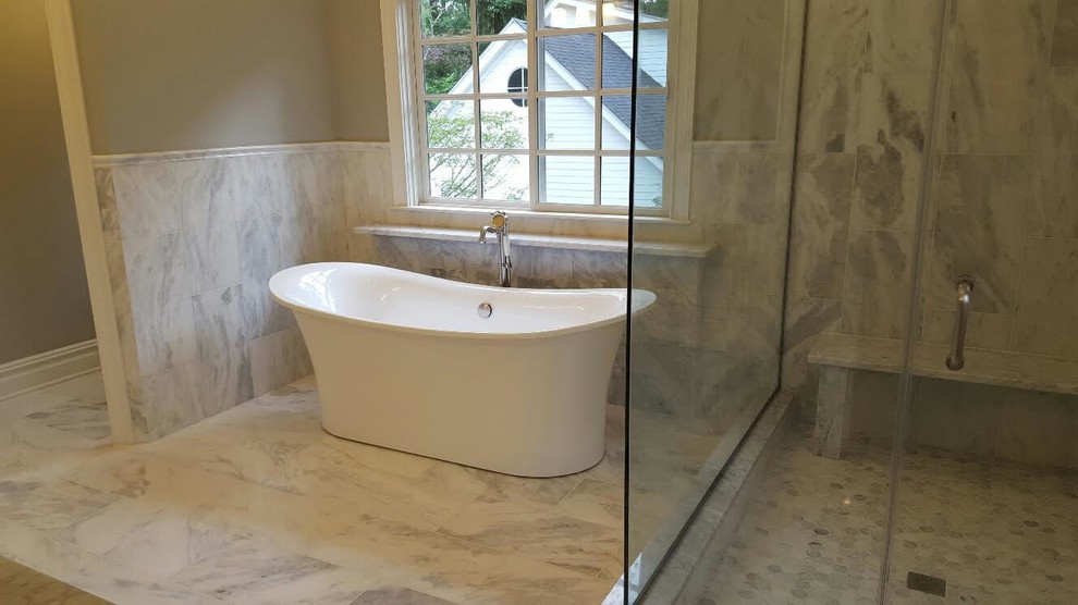 Traditional ensuite bathroom in New York with a freestanding bath, an alcove shower, beige walls and a hinged door.