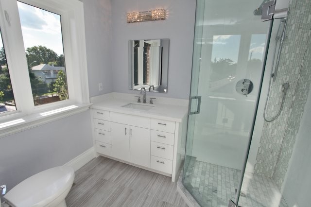 На фото: маленькая ванная комната в современном стиле с плоскими фасадами, белыми фасадами, угловым душем, раздельным унитазом, серой плиткой, белой плиткой, удлиненной плиткой, фиолетовыми стенами, деревянным полом, душевой кабиной, врезной раковиной и столешницей из искусственного камня для на участке и в саду