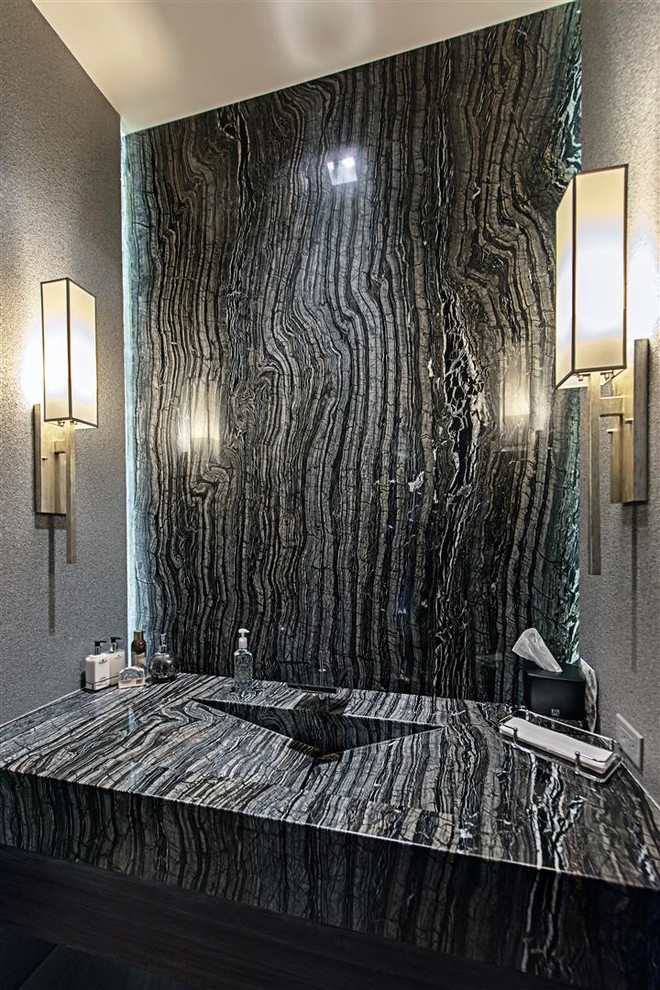 Cette image montre une salle d'eau minimaliste de taille moyenne avec WC à poser, un carrelage noir et blanc, des dalles de pierre, un mur gris, un sol en carrelage de porcelaine, un lavabo intégré, un plan de toilette en zinc et un sol gris.
