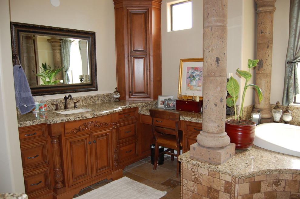 Inredning av ett klassiskt stort en-suite badrum, med luckor med upphöjd panel, ett platsbyggt badkar, beige kakel, stenkakel, beige väggar, travertin golv, granitbänkskiva, skåp i mellenmörkt trä, en dusch i en alkov, en toalettstol med hel cisternkåpa och ett undermonterad handfat