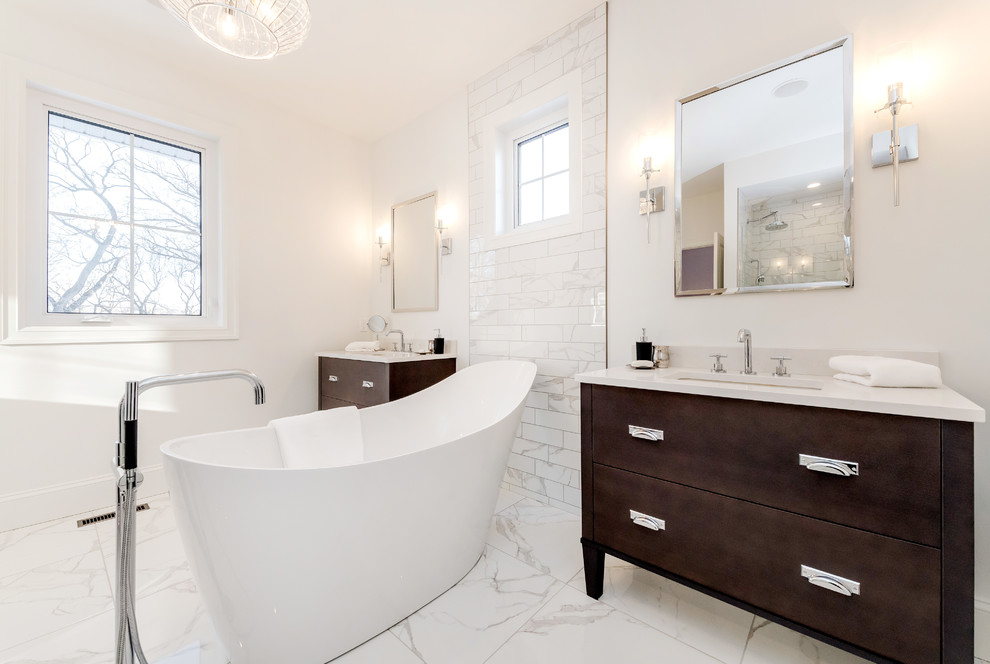Inredning av ett klassiskt litet badrum för barn, med släta luckor, skåp i mellenmörkt trä, ett fristående badkar, vit kakel, marmorkakel, vita väggar, marmorgolv, ett undermonterad handfat, bänkskiva i kvartsit och vitt golv