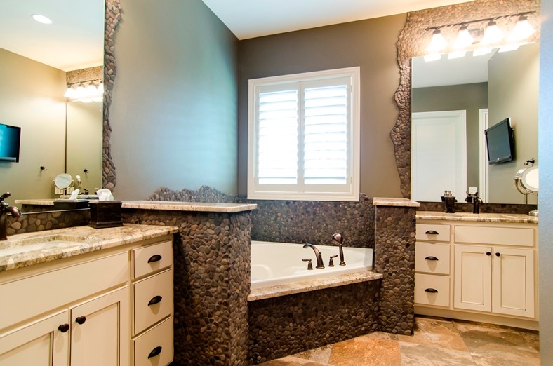 Exemple d'une grande salle de bain chic avec un mur gris, un sol en carrelage de céramique, un lavabo encastré, un placard à porte shaker, des portes de placard blanches, une baignoire d'angle, un carrelage noir et blanc, un carrelage marron, une plaque de galets et un plan de toilette en marbre.