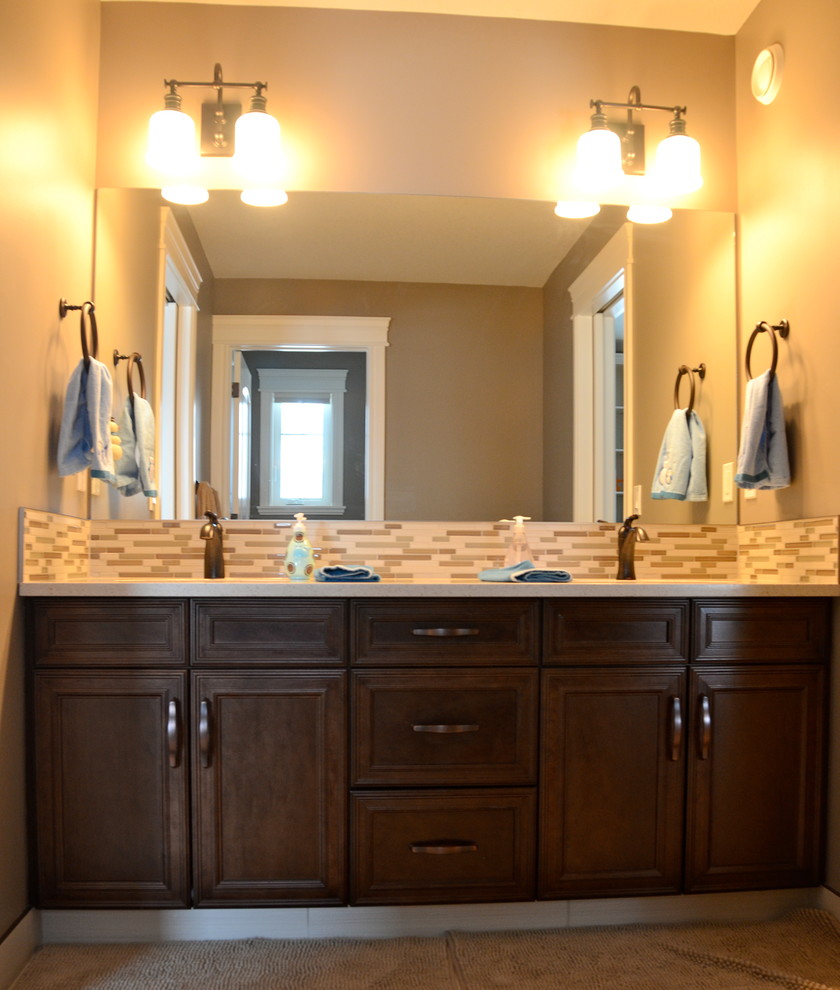 Example of a classic beige tile bathroom design in Calgary with an undermount sink, flat-panel cabinets, dark wood cabinets and quartz countertops