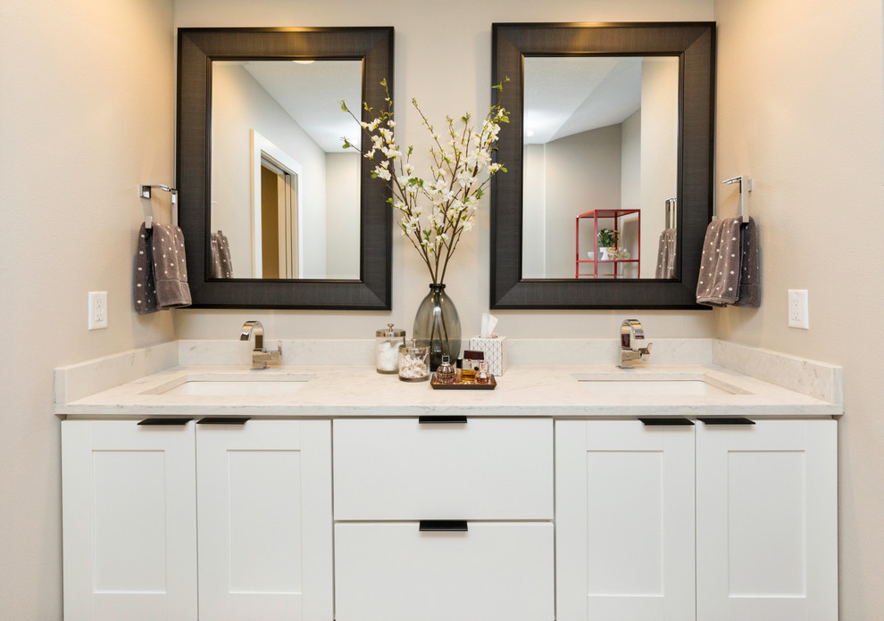 Ejemplo de cuarto de baño principal actual con armarios estilo shaker, puertas de armario blancas, bañera exenta, paredes beige, suelo de madera oscura y lavabo bajoencimera